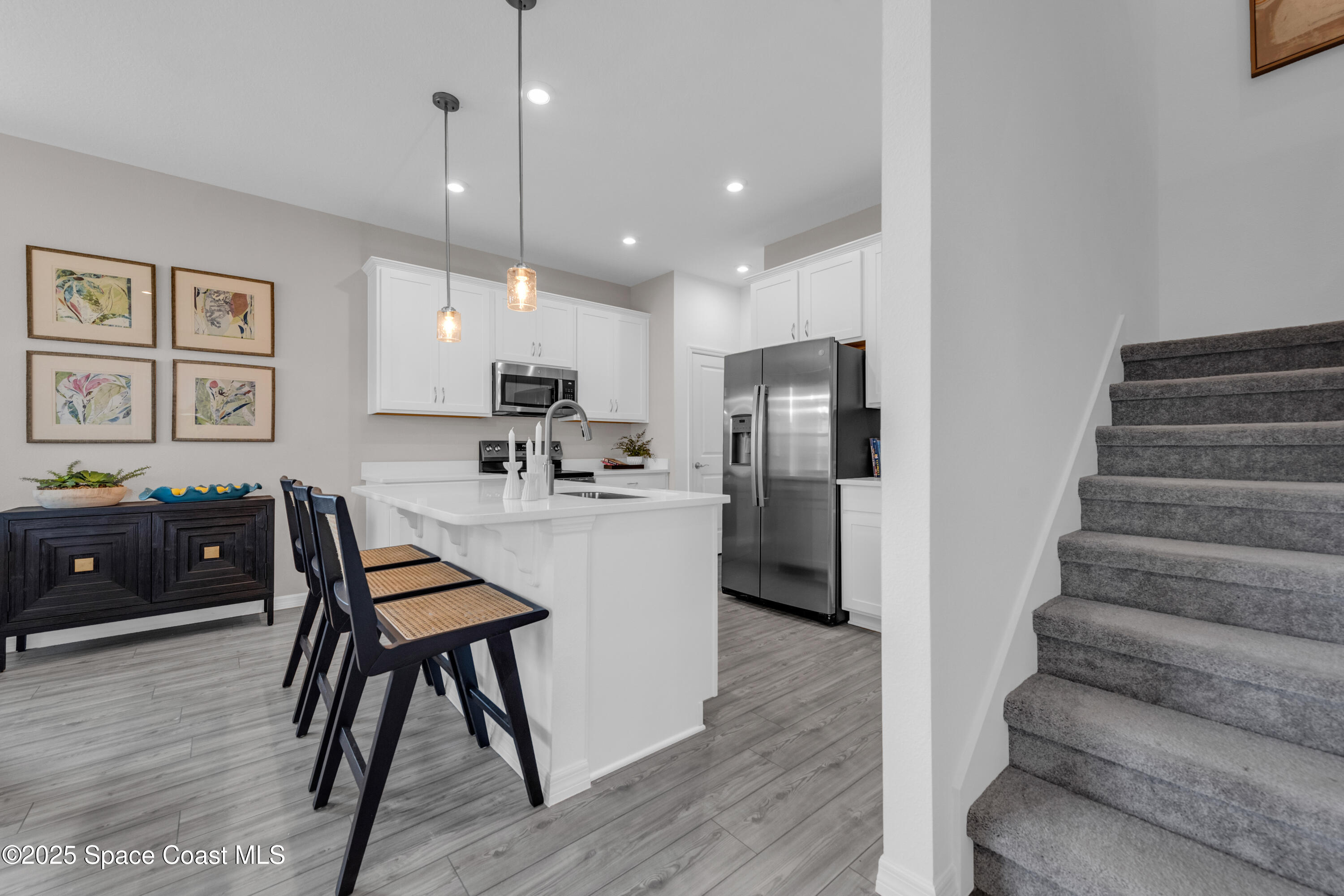 615 Poller Way Cocoa, FL 32927 - Photo 8 of 29 a kitchen with stainless steel appliances kitchen island granite countertop a refrigerator a stove a sink dishwasher and a dining table with wooden floor