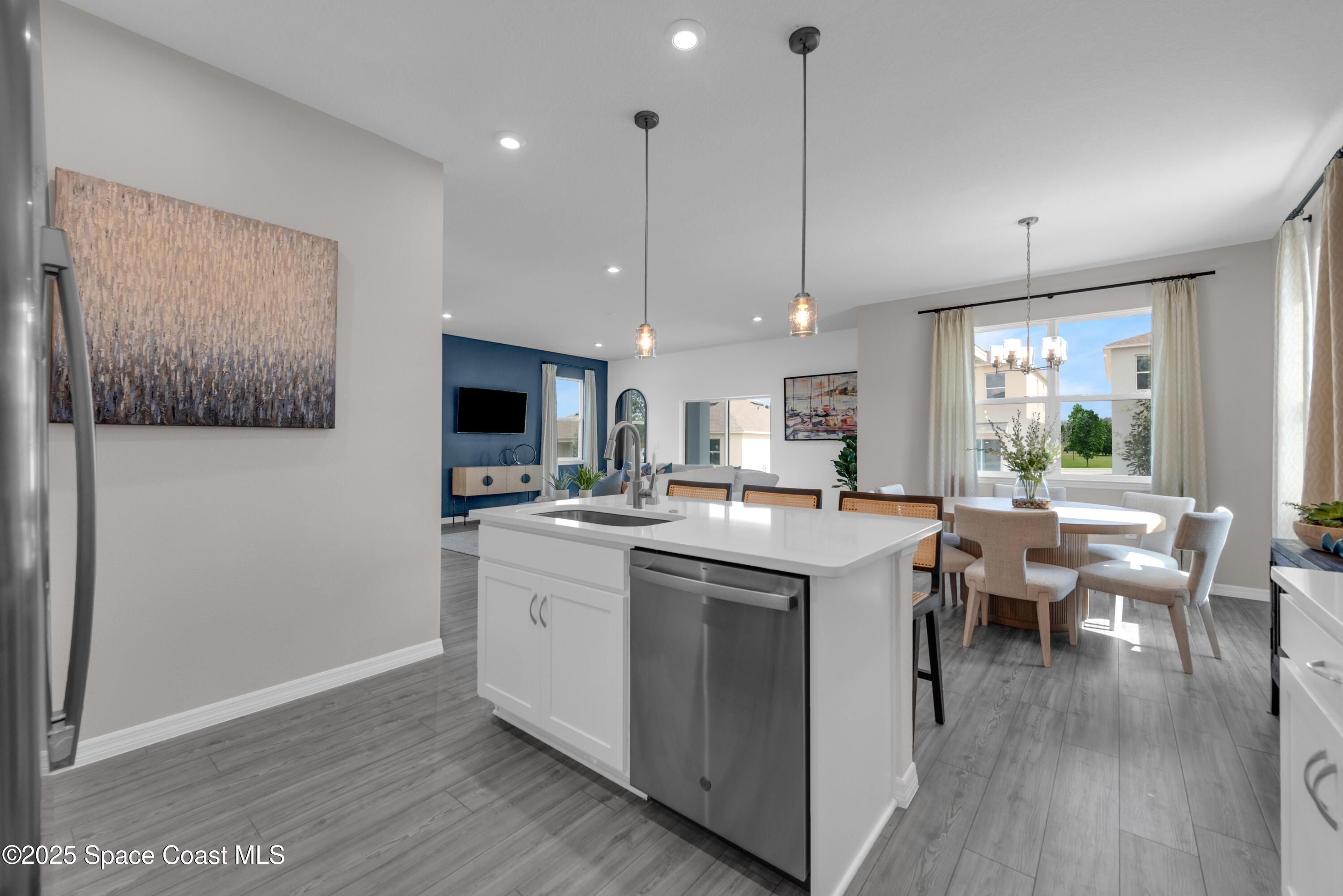 615 Poller Way Cocoa, FL 32927 - Photo 10 of 29 a kitchen with stainless steel appliances granite countertop a sink a stove a refrigerator and a dining table with wooden floor