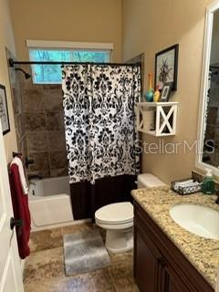 7971 Southwest 80th Lane Gainesville, FL 32608 - Photo 14 of 22 a bathroom with a granite countertop toilet sink and mirror