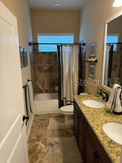 7971 Southwest 80th Lane Gainesville, FL 32608 - Photo 17 of 22 a bathroom with a granite countertop sink a mirror and a bath tub