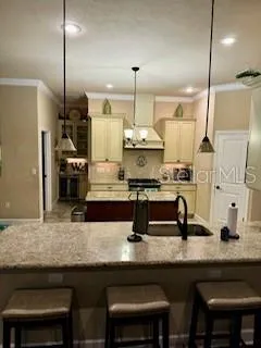 a kitchen with granite countertop a sink chairs and cabinets