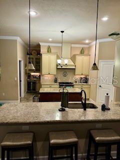 7971 Southwest 80th Lane Gainesville, FL 32608 - Photo 4 of 22 a kitchen with granite countertop a sink chairs and cabinets