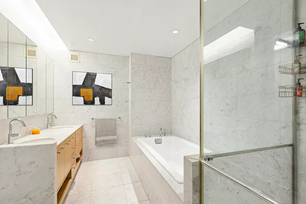 a bathroom with a tub a sink a mirror and a shower