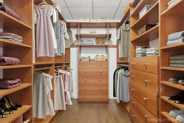 a view of walk in closet with clothes and shoes