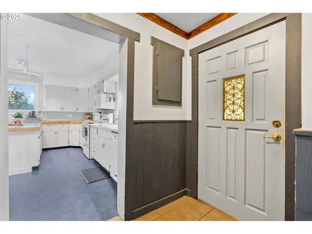 a open kitchen with white cabinets and wooden floor