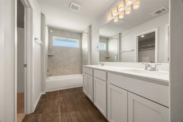 a bathroom with a sink a large mirror and a bathtub