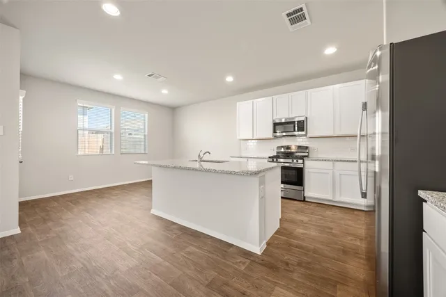 a kitchen with white cabinets and stainless steel appliances