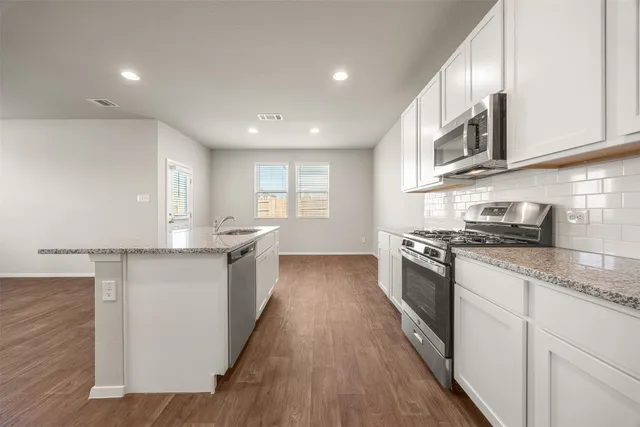 a view of kitchen with wooden floor and electronic appliances
