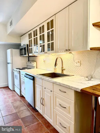 a large kitchen with granite countertop a large stove a sink dishwasher and a refrigerator