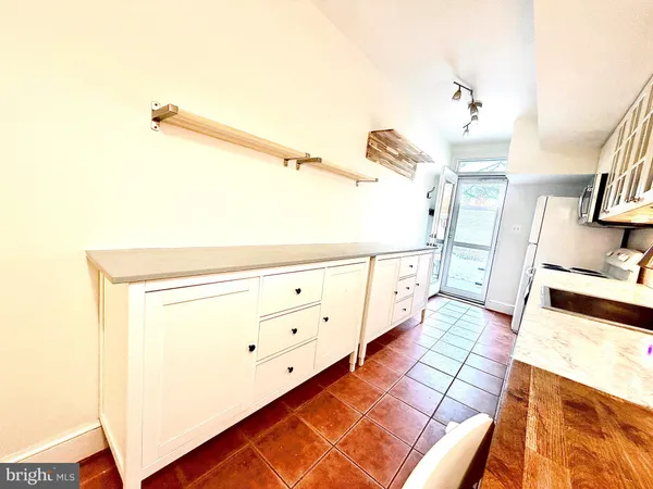 a backyard of a house with barbeque oven table and chairs