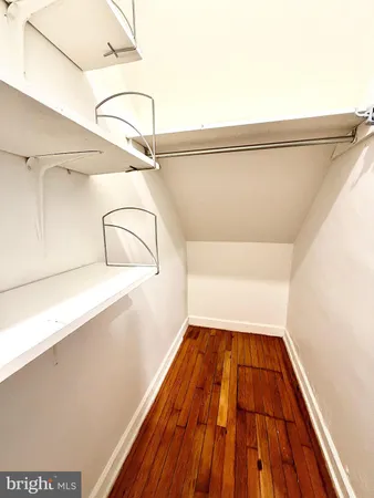 a view of a bedroom with wooden floor and windows