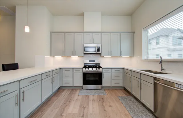 a kitchen with cabinets stainless steel appliances and a sink