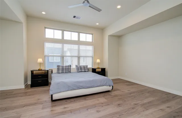 a large bedroom with a bed and a large window