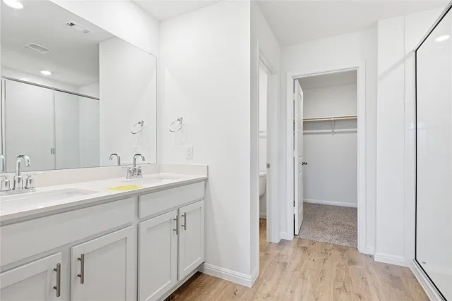 a spacious bathroom with a double vanity sink a mirror and a