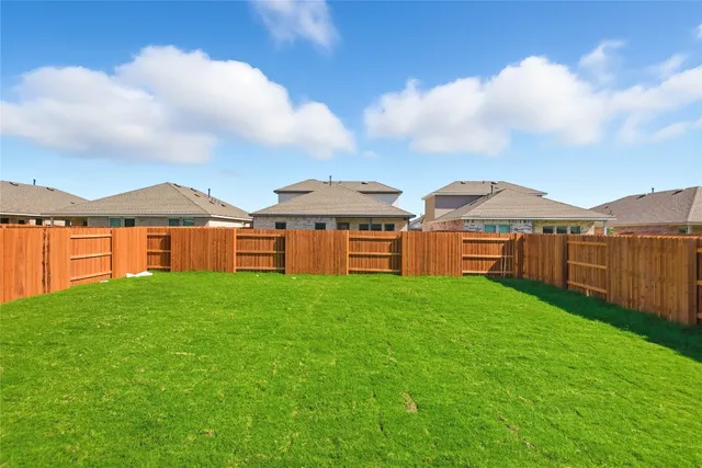 a view of a yard with a house in the background