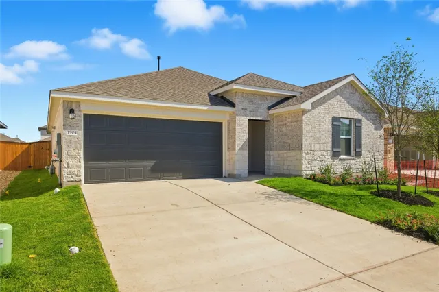 a front view of a house with a garden and plants