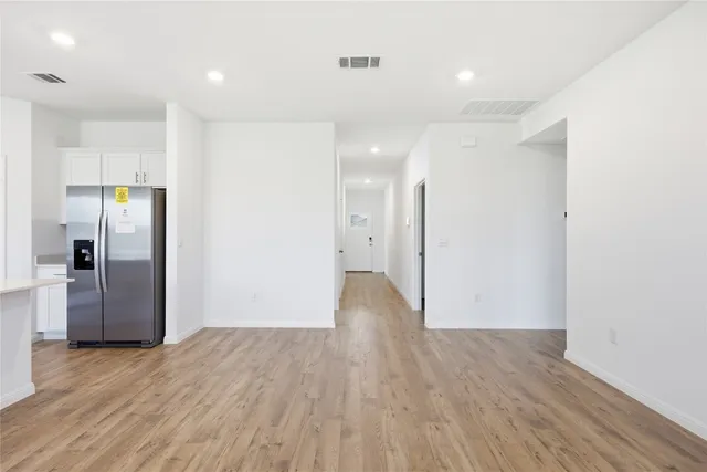 a view of an empty room with wooden floor