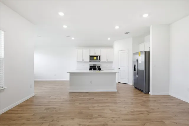 a view of kitchen with stainless steel appliances granite countertop a refrigerator a sink and a stove