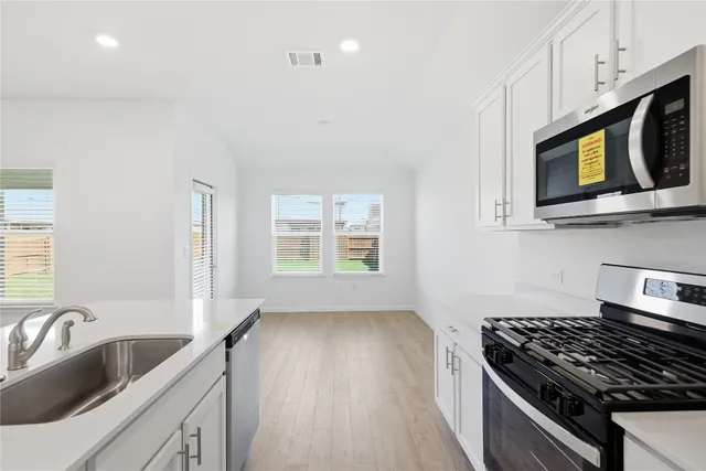 a kitchen with stainless steel appliances granite countertop a sink stove and microwave