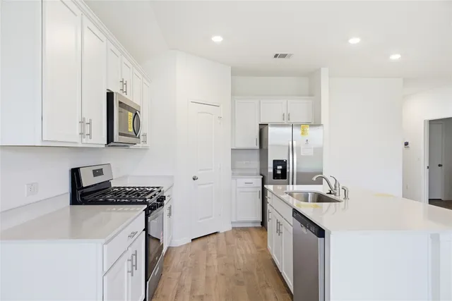 a kitchen that has a sink a stove and a refrigerator
