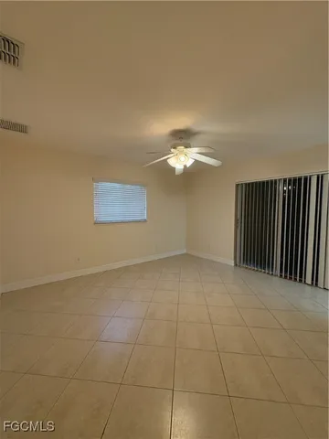 a view of an empty room with a chandelier fan