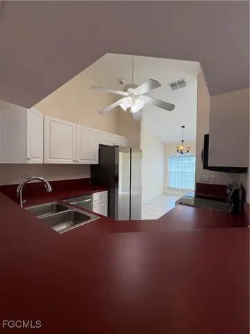 a kitchen with stainless steel appliances granite countertop a sink and a refrigerator