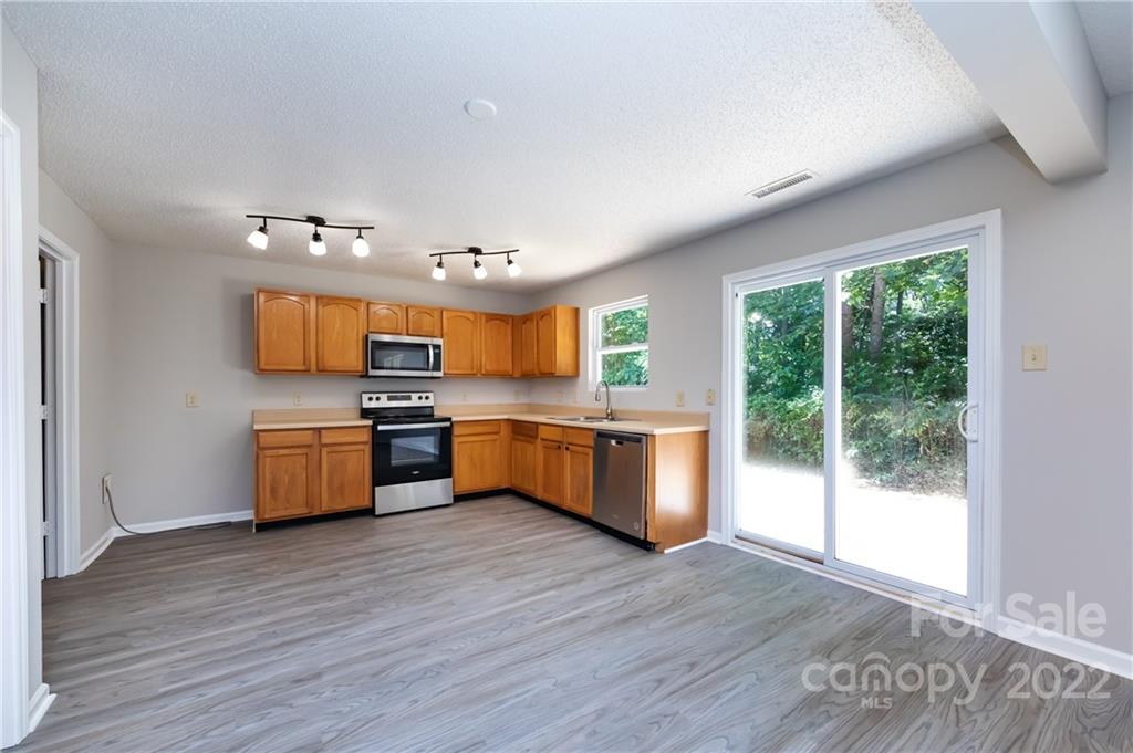 776 Ladino Lane Clover, SC 29710 - Photo 15 of 44 a large kitchen with stainless steel appliances granite countertop a sink cabinets and wooden floor