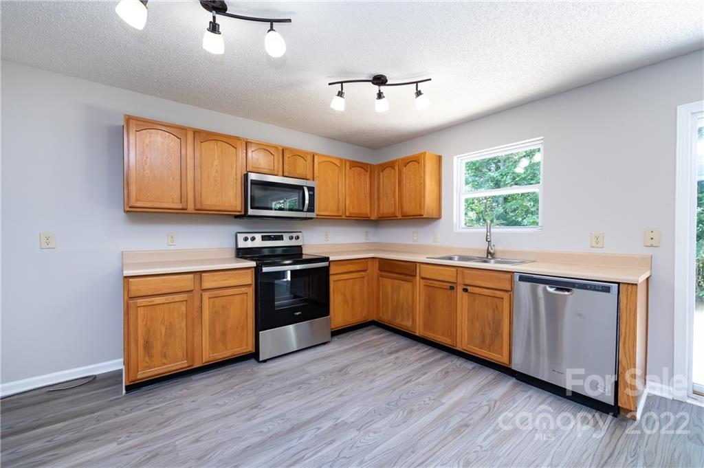 776 Ladino Lane Clover, SC 29710 - Photo 18 of 44 a kitchen with stainless steel appliances granite countertop wooden floors a stove a microwave a sink and dishwasher with wooden floor