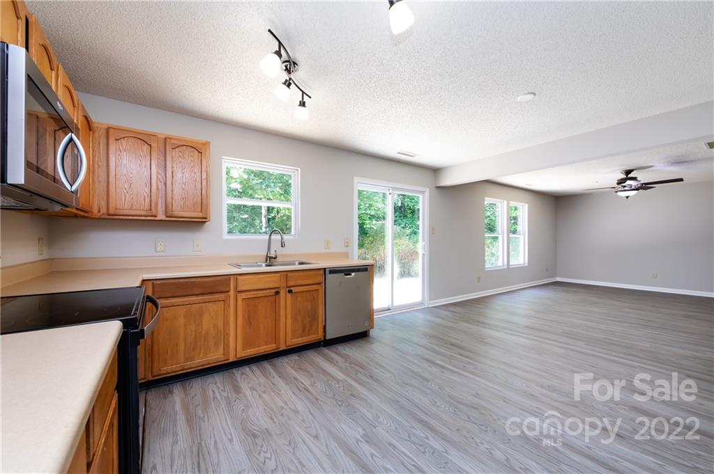 776 Ladino Lane Clover, SC 29710 - Photo 20 of 44 a kitchen with stainless steel appliances granite countertop wooden cabinets a stove a sink and dishwasher with wooden floor