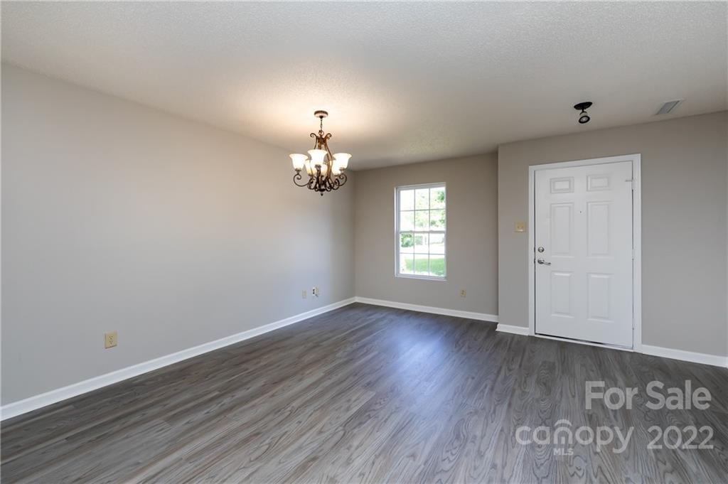 776 Ladino Lane Clover, SC 29710 - Photo 6 of 44 an empty room with wooden floor chandelier and windows