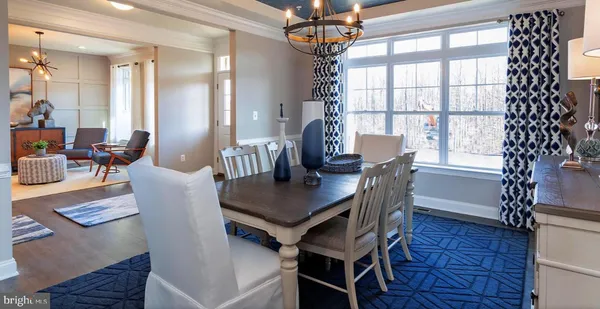 a kitchen with kitchen island a dining table chairs stainless steel appliances and cabinets