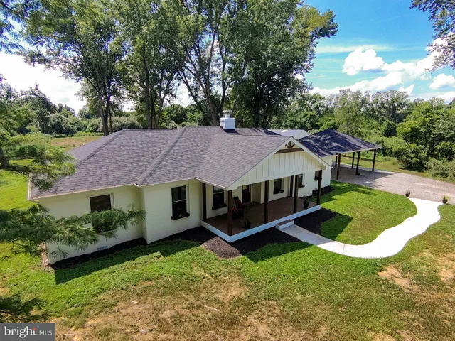 a aerial view of a house with swimming pool and trees in the background