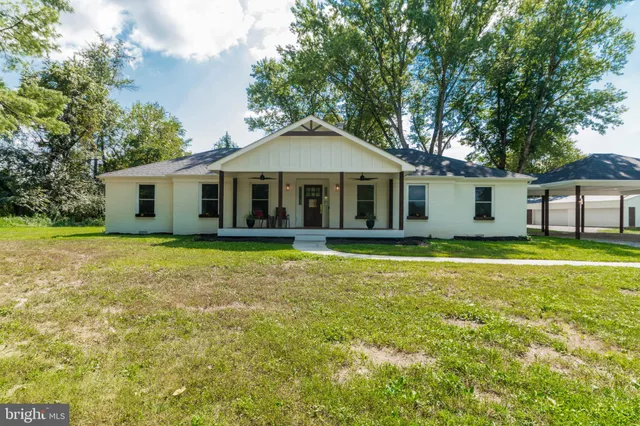 a view of a hallway with wooden floor and a living room