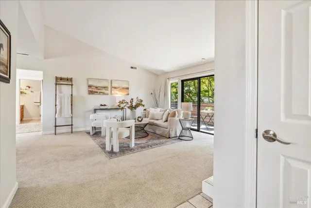 a living room with furniture large window and a view of bedroom