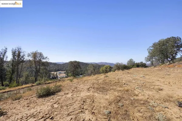 a view of a dry yard with mountains in the background