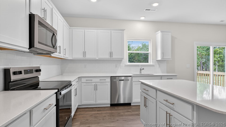 152 Charlies Bnd Way Spring Lake, NC 28390 - Photo 13 of 34 a kitchen with white cabinets appliances a sink and a window