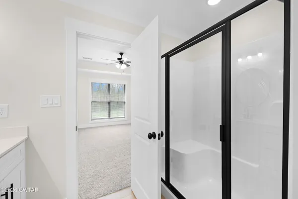 a bathroom with a glass shower door and a mirror
