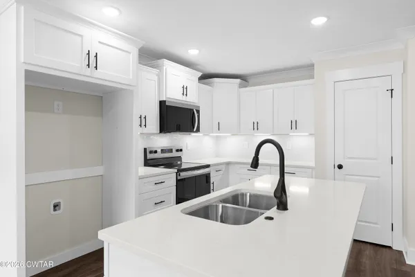 a kitchen with sink a refrigerator and cabinets