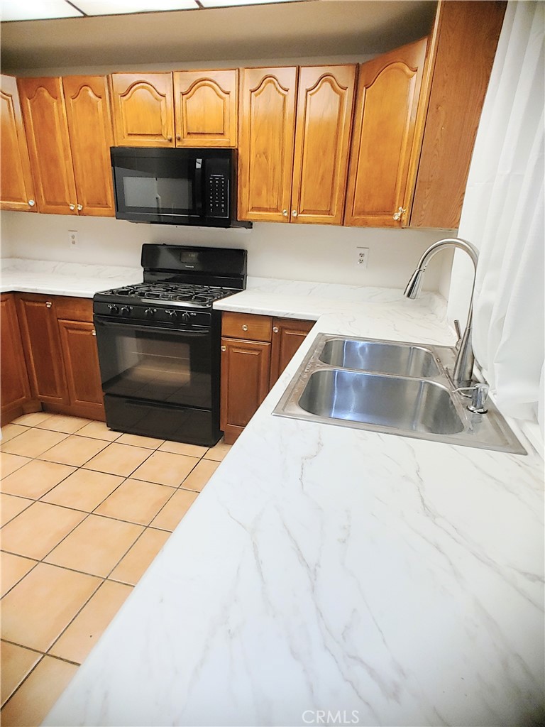 49409 Eisenhower Drive Indio, CA 92201 - Photo 20 of 30 a kitchen with stainless steel appliances a stove a microwave and a sink