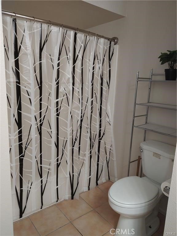 49409 Eisenhower Drive Indio, CA 92201 - Photo 29 of 30 a white toilet sitting next to a shower curtain