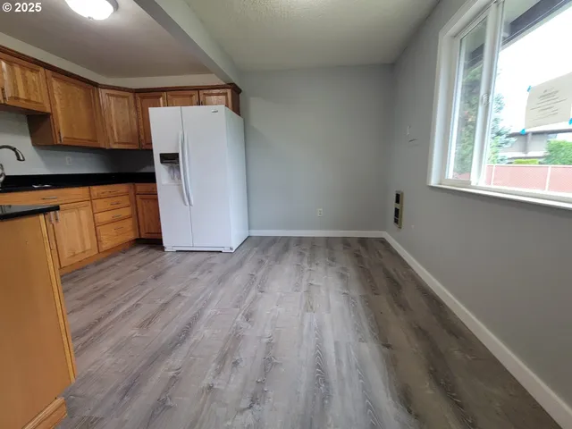 a view of a kitchen with wooden floor and a window