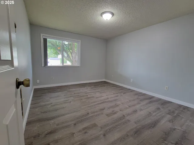 an empty room with wooden floor and window
