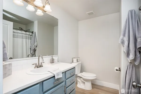 a bathroom with a sink a toilet and a mirror
