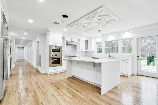 a kitchen with stainless steel appliances kitchen island hardwood floor sink and stove