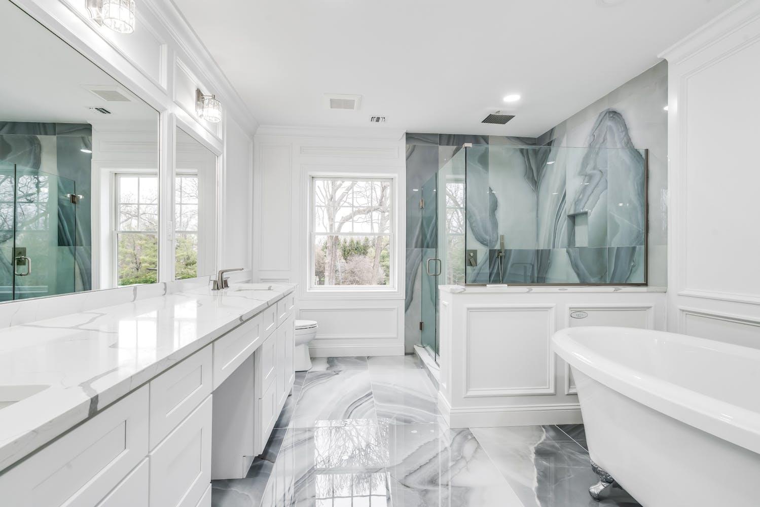 539 Split Rock Road Syosset, NY 11791 - Photo 22 of 40 a large white bathroom with a large tub a sink and a large mirror next to a window