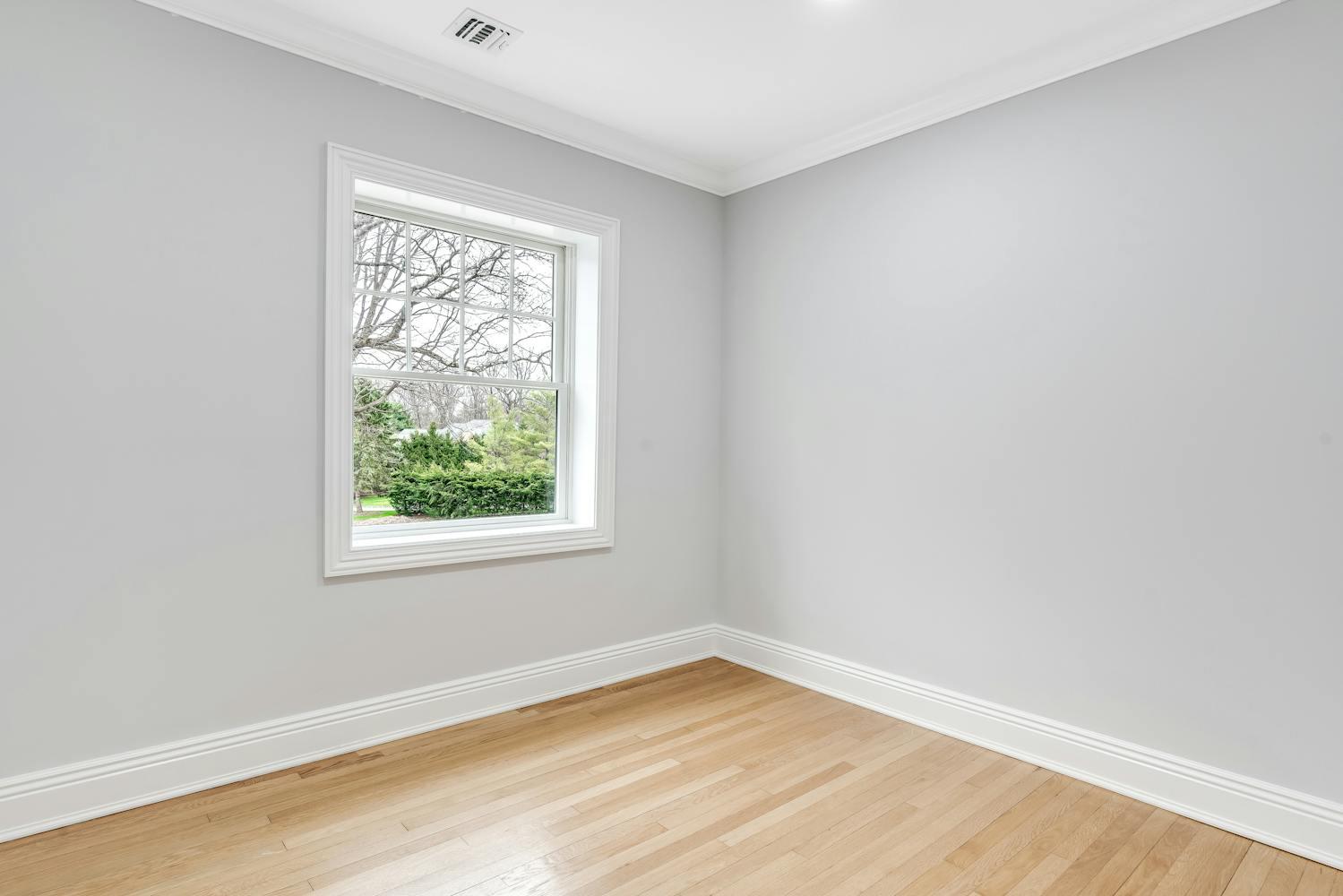 539 Split Rock Road Syosset, NY 11791 - Photo 25 of 40 an empty room with wooden floor and windows