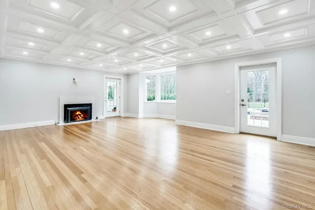 an empty room with wooden floor and fireplace