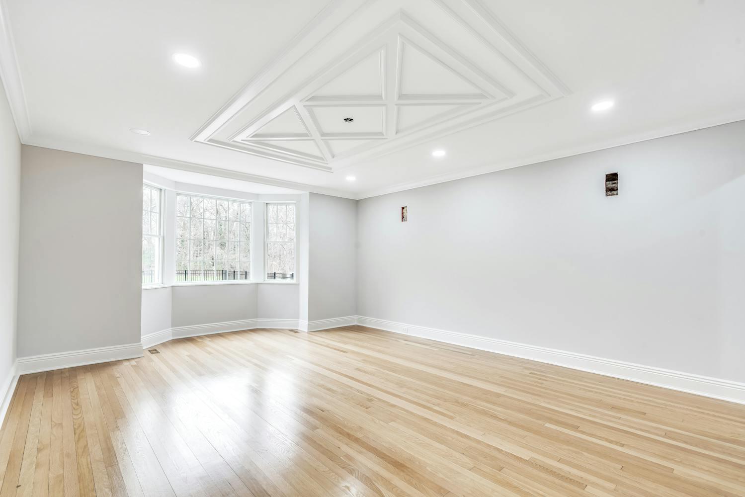 539 Split Rock Road Syosset, NY 11791 - Photo 10 of 40 an empty room with wooden floor and windows