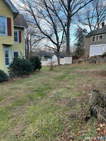 a view of a yard in front of a house with large trees