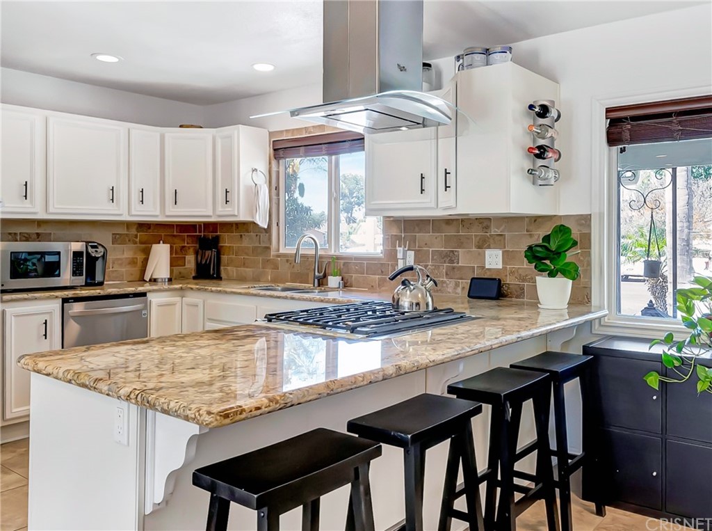 6720 Kurl Way Reseda, CA 91335 - Photo 7 of 40 a kitchen with granite countertop a table chairs stove and cabinets